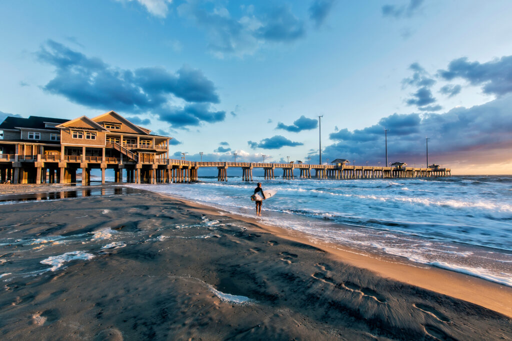 Surfer la rasaritul soarelui la Jeanette's Pier din Nags Head, Carolina de Nord
