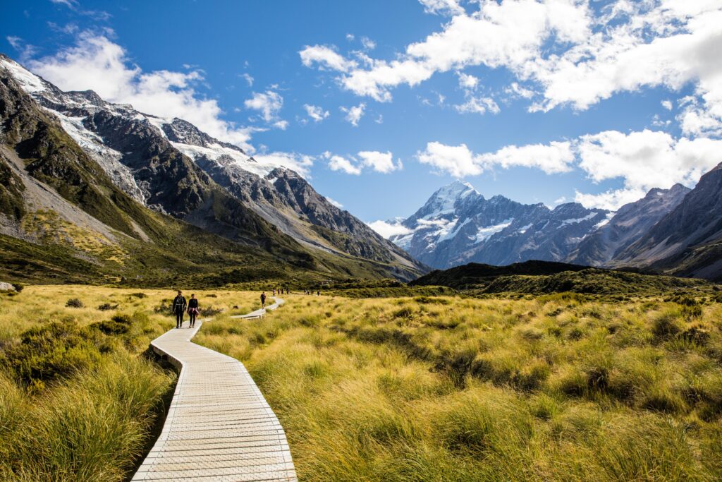 Oameni care se plimba pe o promenada de lemn din Parcul National Aoraki/Mount Cook, Noua Zeelanda