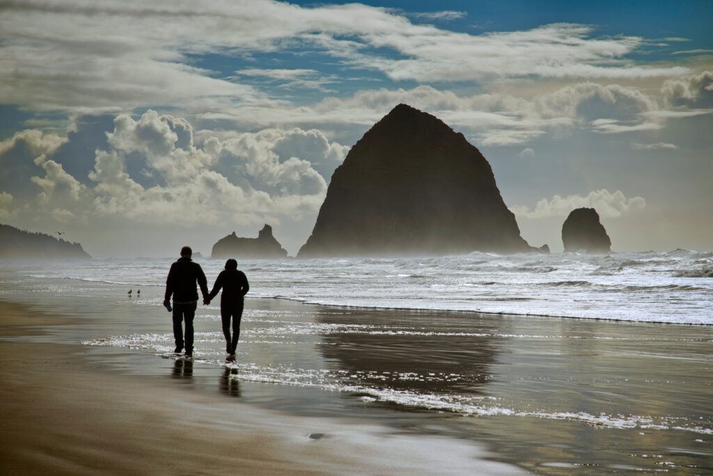 Cuplu care se plimba pe Cannon Beach, Oregon